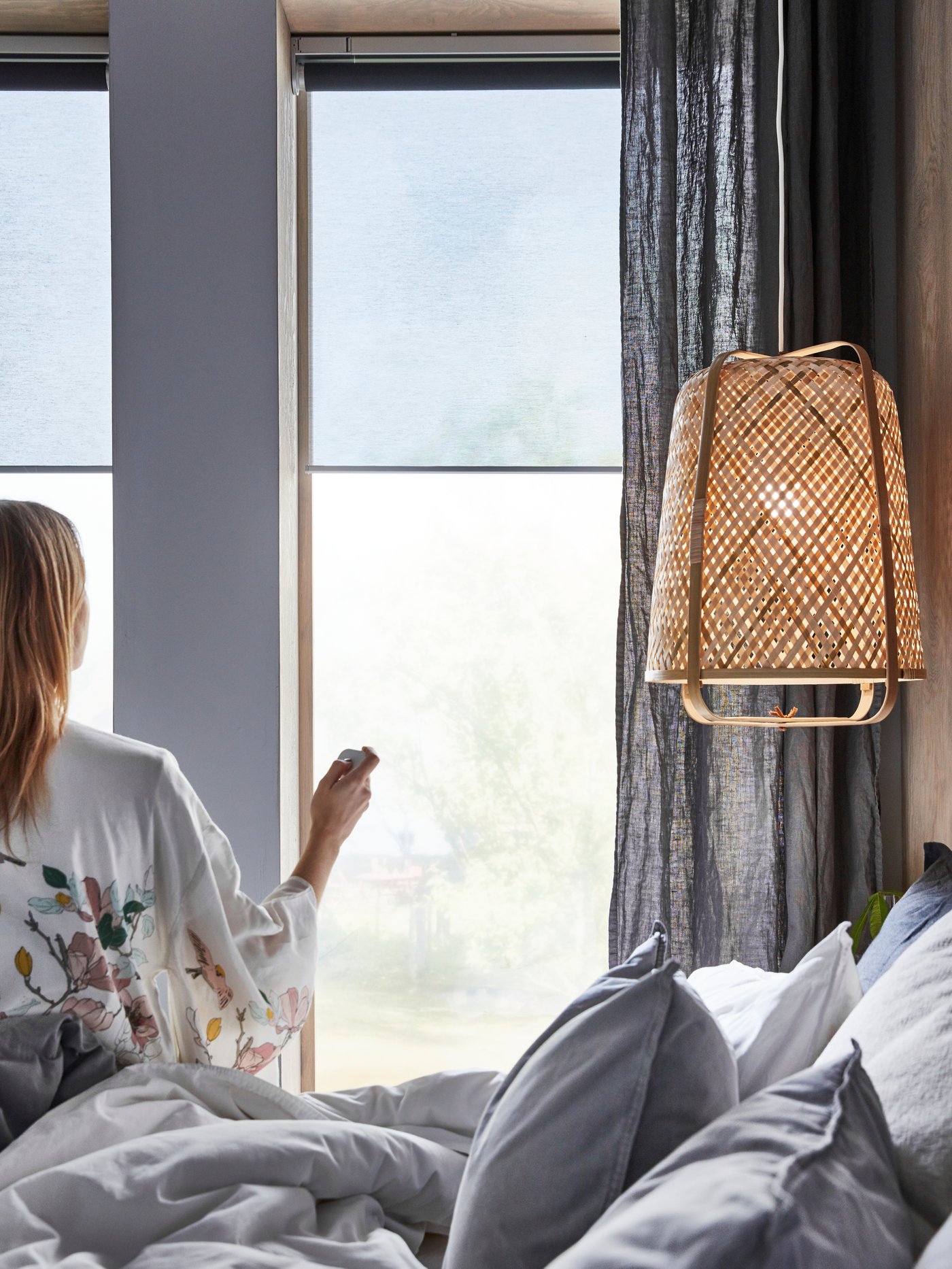 Eine Frau schaltet einen Lampe mit einem IKEA smart led Leuchtmittel ein