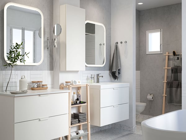 A bathroom with a tub and two mirrors.