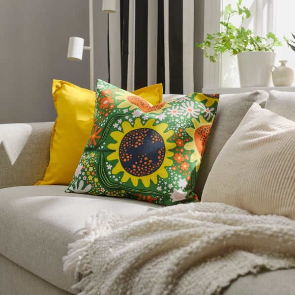 A green multicolour/floral pattern CAFEBITRÄDE cushion cover in the living room