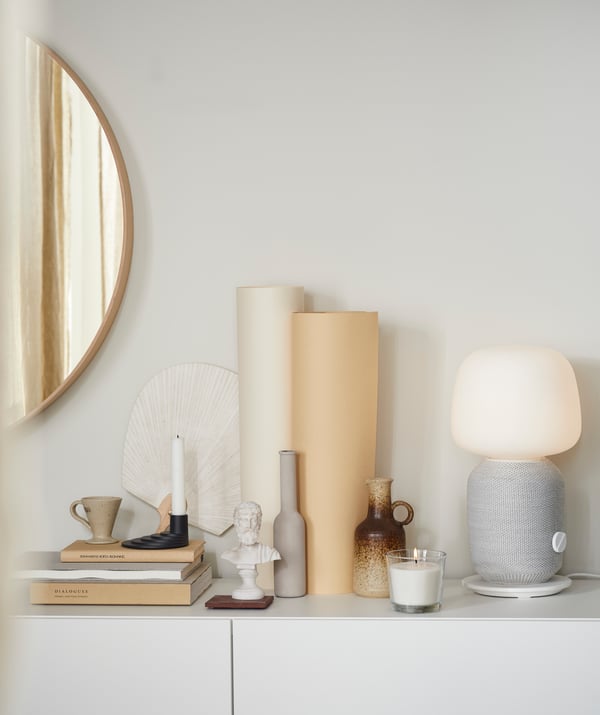Dekorieren im Scandi Boho Stil funktioniert einfach indem man Dekorationsgegenstände wie Vasen, Lampen, Spiegel oder Kerzenhalter in gedeckten Tönen in Gruppen zusammenstellt.