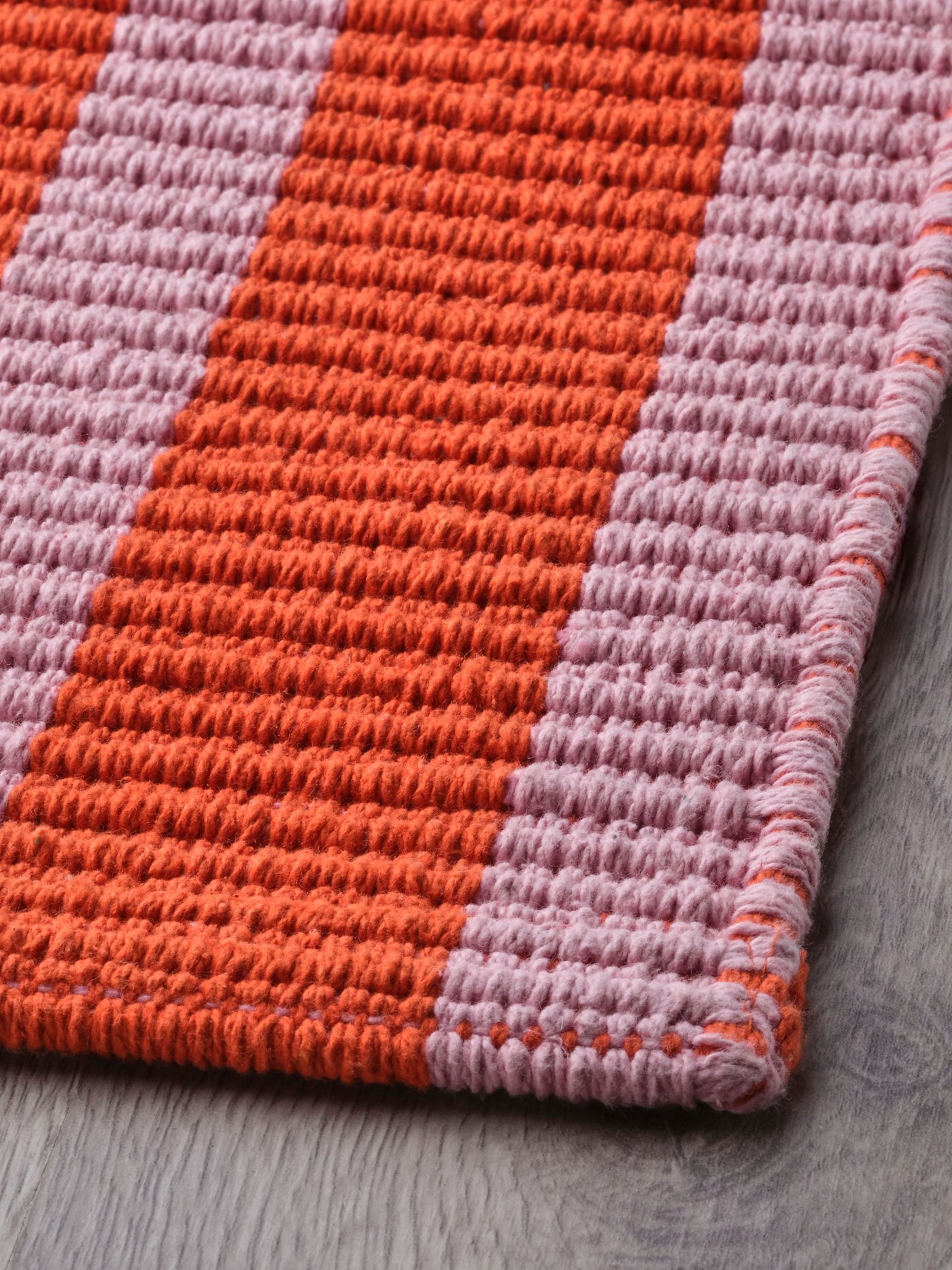 A pink/orange VÄGSKYLT door mat