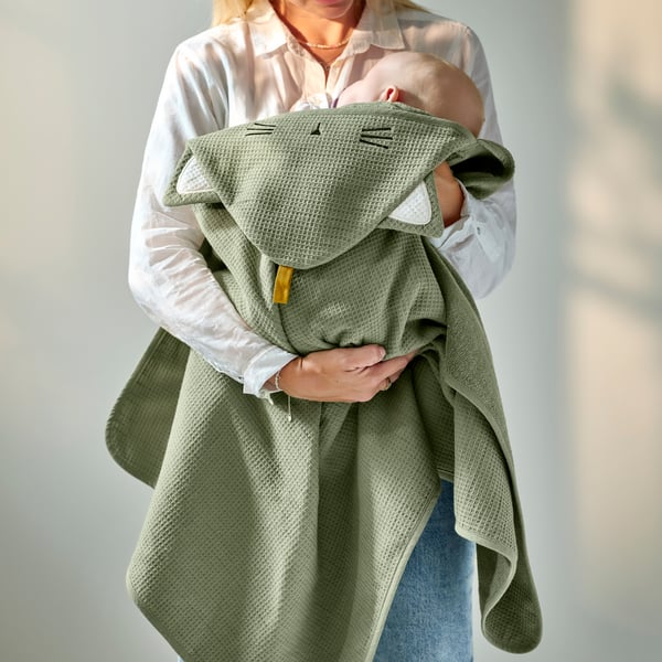 A green GULDVÄVARE baby towel with hood