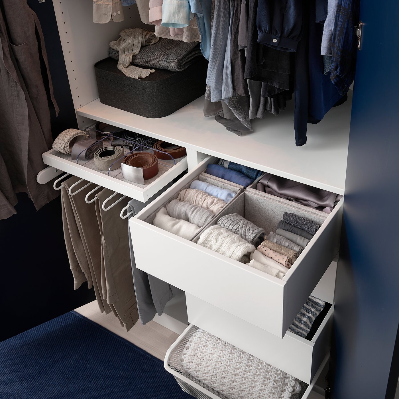 Teil eines Kleiderschranks mit unterschiedlichen Möglichkeiten für mehr Ordnung rund um Hosen, Gürtel und gefaltete Socken