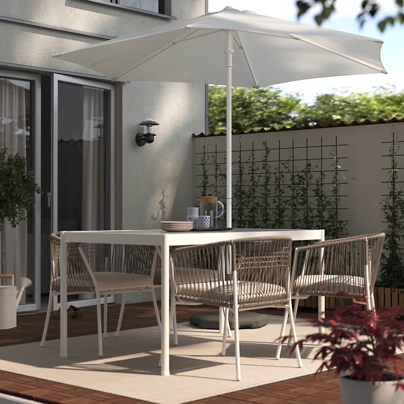 SEGERÖN outdoor dining table and chairs on a patio under a HOGON parasol, on top of an outdoor rug in the sunlight.