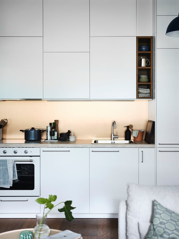 Open, witte METOD keuken met SÄLJAN laminaatwerkblad met beige steenpatroon en witte MATTRADITION heteluchtoven.
