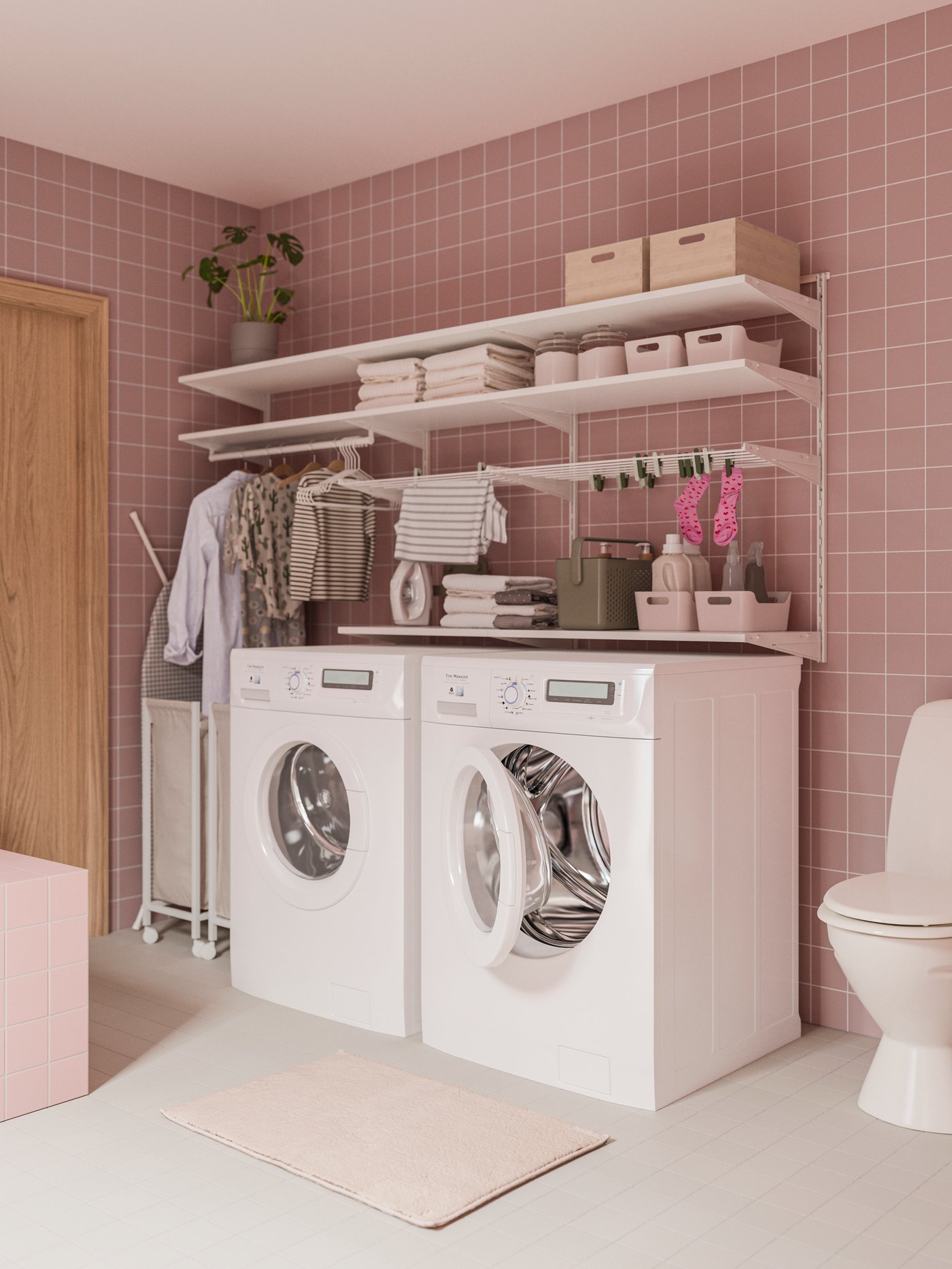 Ljus tvättstuga med rosa kakel, två tvättmaskiner, hyllor med handdukar och en toalett till höger.
