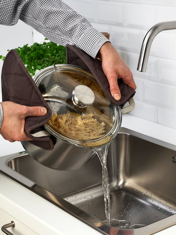 Olla HEMKOMST llena de tallarines y dejando el agua caer.