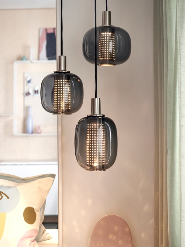 A HÖGVIND pendant lamp with three lamps lamps hang from the ceiling.