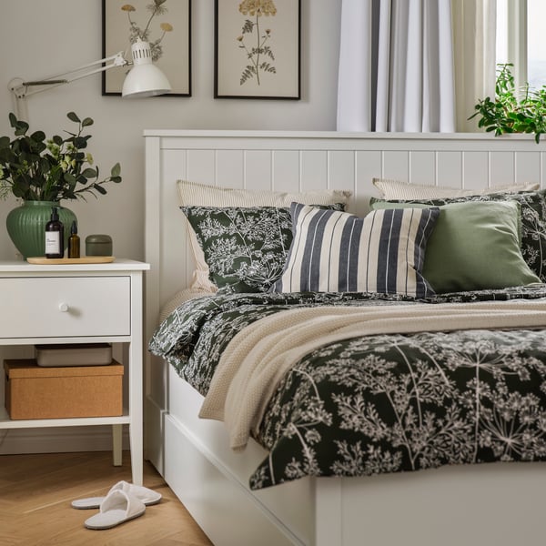 Gemütliches Schlafzimmer mit GULLABERG Nachttisch und Bettgestell, bezogen mit DAGGBJÖRNBÄR Bettwäsche sowie dekoriert mit Kissen und einer Tagesdecke.