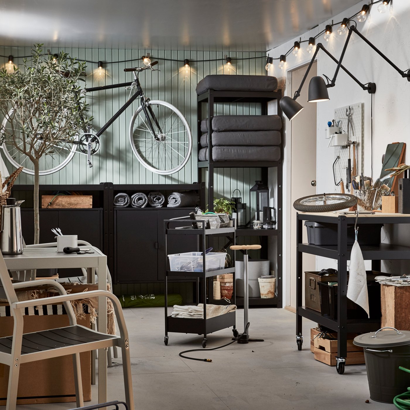 A garage-like interior with wall-hung bike, shelving units with outdoor stuff; seating, coffee, mood and functional lighting.