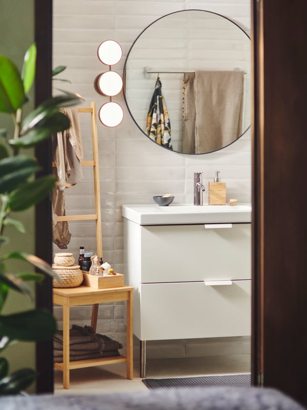 A bathroom sink cabinet with a mirror.