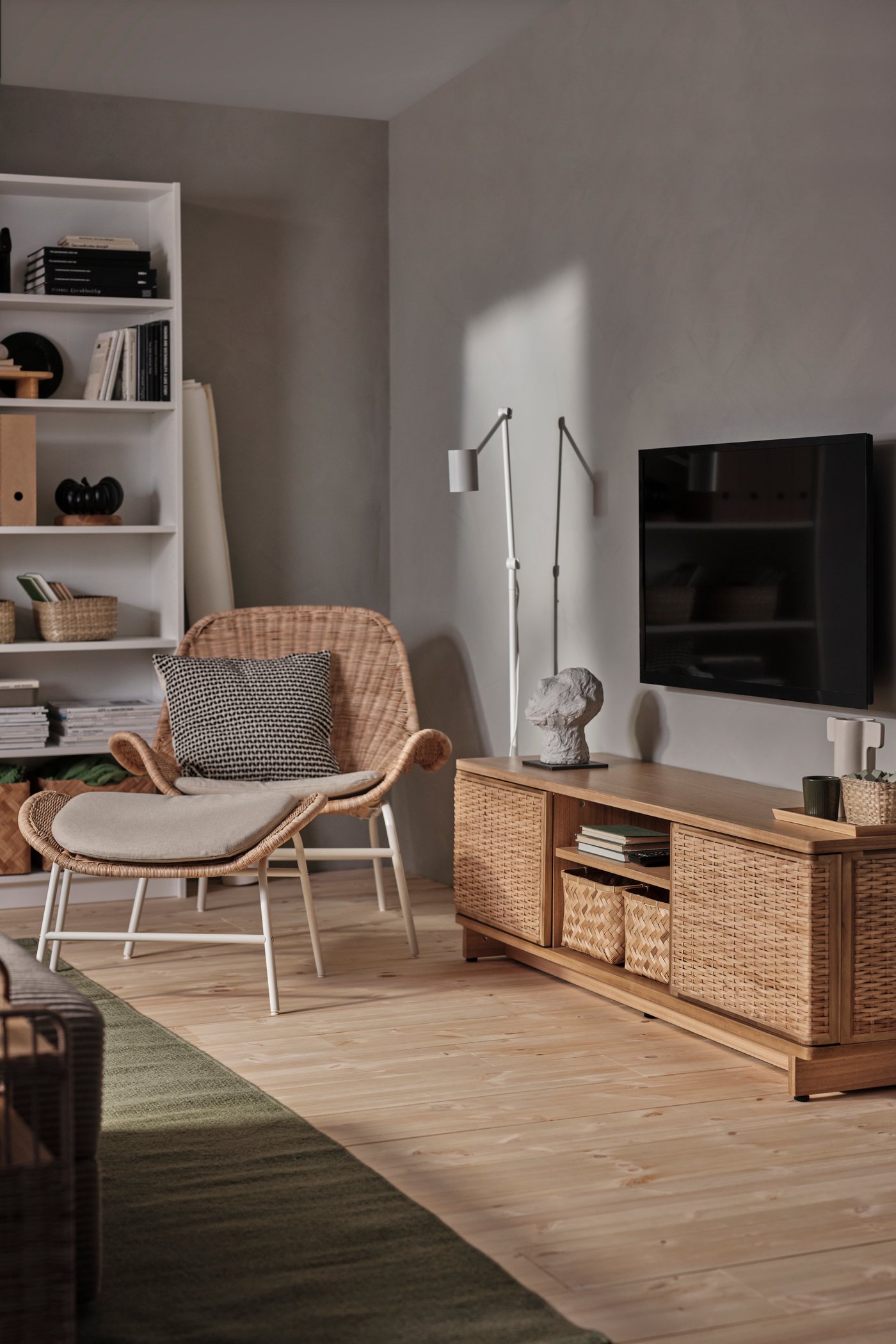 Fauteuil FRYKSÅS en rotin/Risane naturel avec coussin dans un salon.