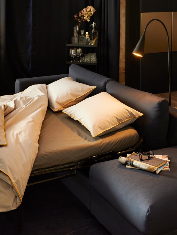 A VILME sofa bed with light-coloured bed linen from our KUNGSBLOMMA collection