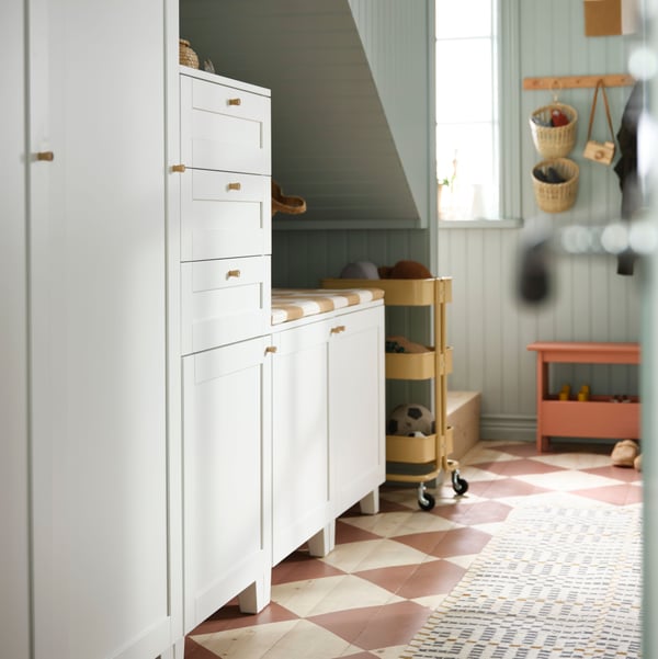A combination of different PLATSA storage cabinets under a spandrel space below a staircase in a hallway.