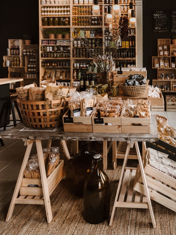 Casa Navarro, en spansk delikatessbutik med träinredning, där varor som burkar, flaskor och förpackade produkter är vackert exponerade på hyllor och bord.