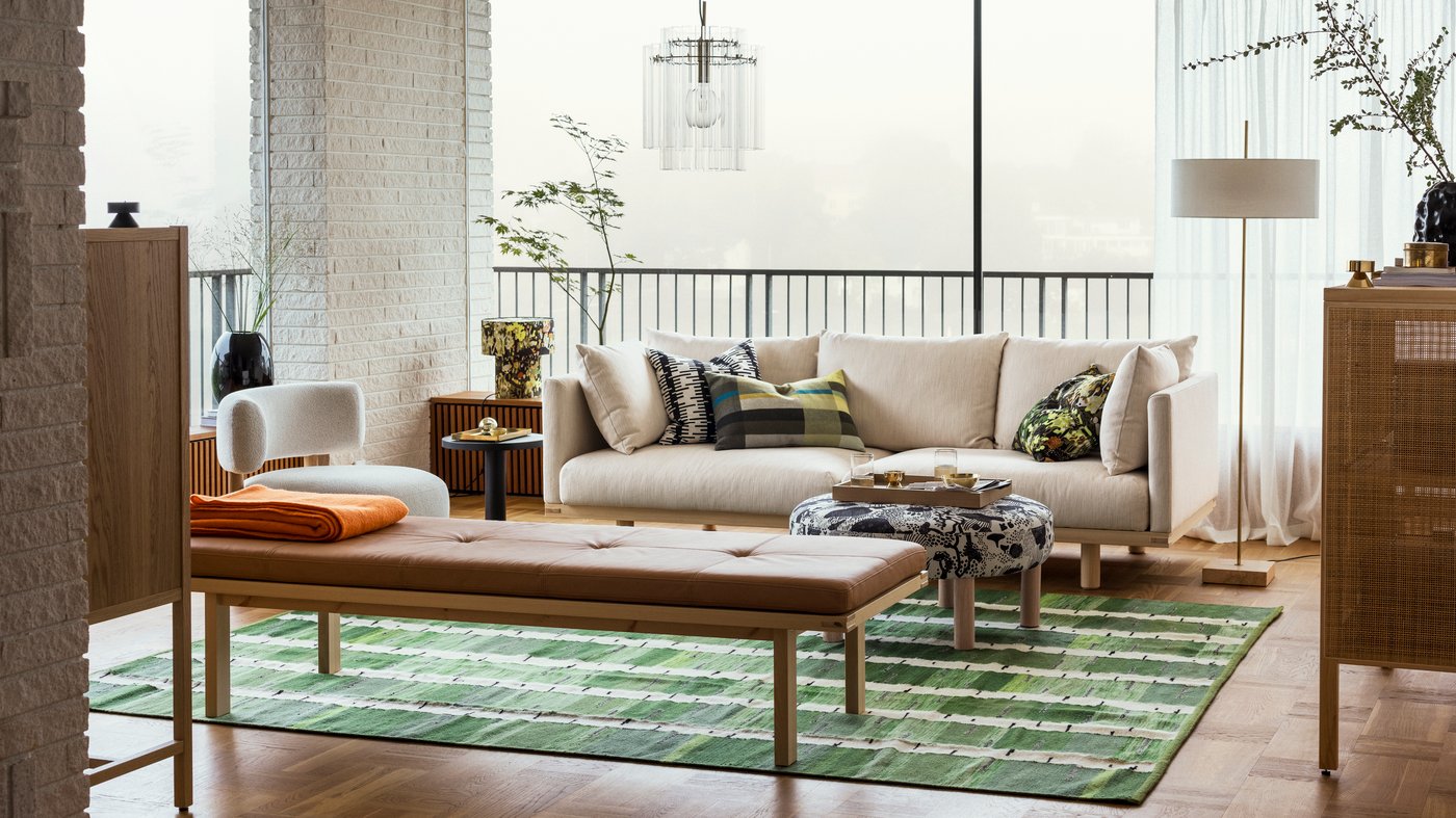 A light living room with STOCKHOLM 2025 furniture, rug, lamps and textiles.