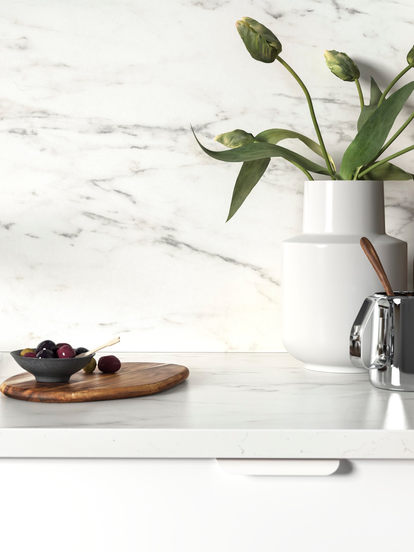 A white EKBACKEN worktop with marble effect, olives on a wooden chopping board, and a white vase with tulips on top.