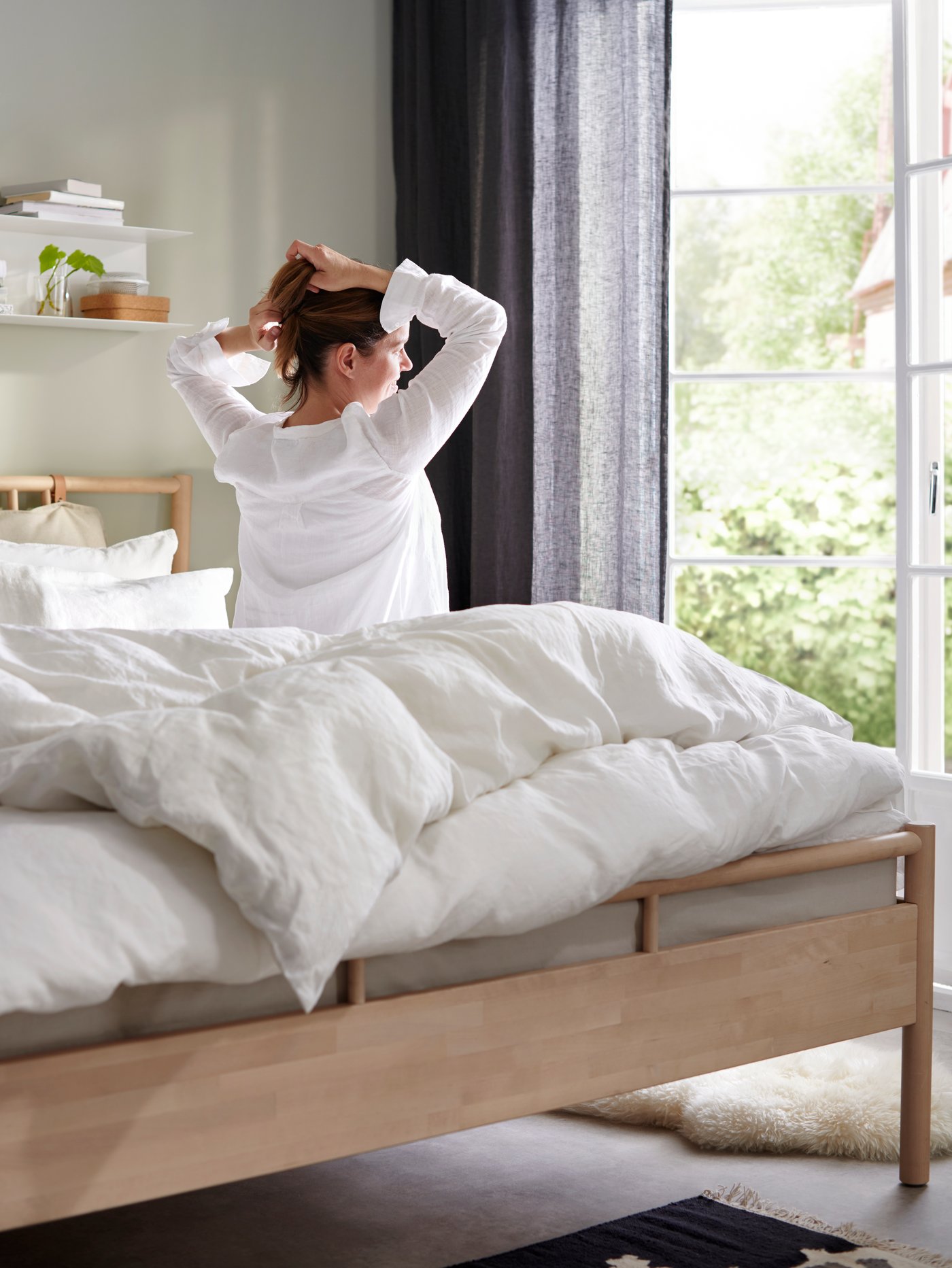 A white BOTKYRKA wall shelf in the bedroom