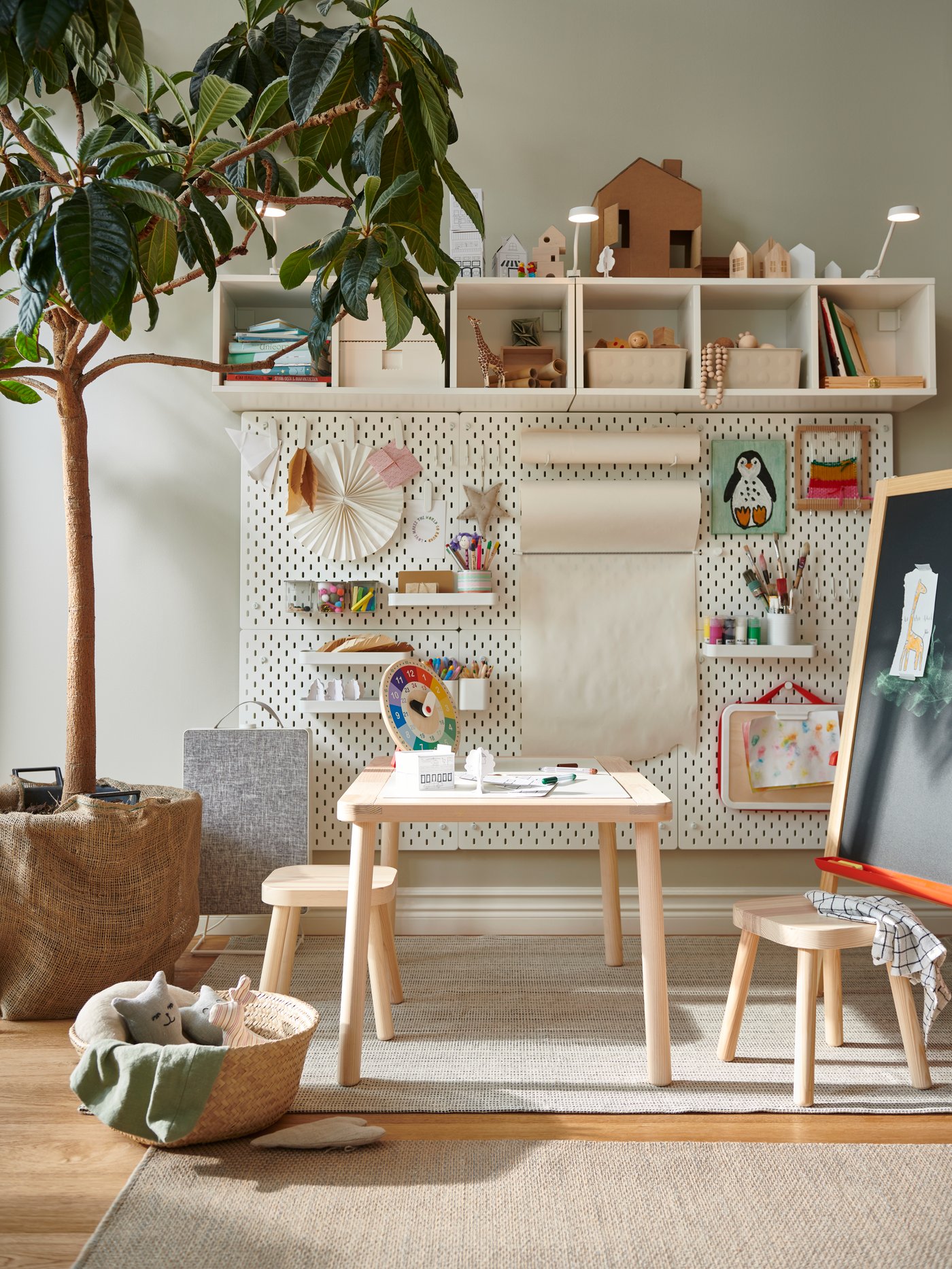 A creative child's room a FLISAT children's table and stools in pine with wall-mounted storage and SKÅDIS pegboards to store small storage.