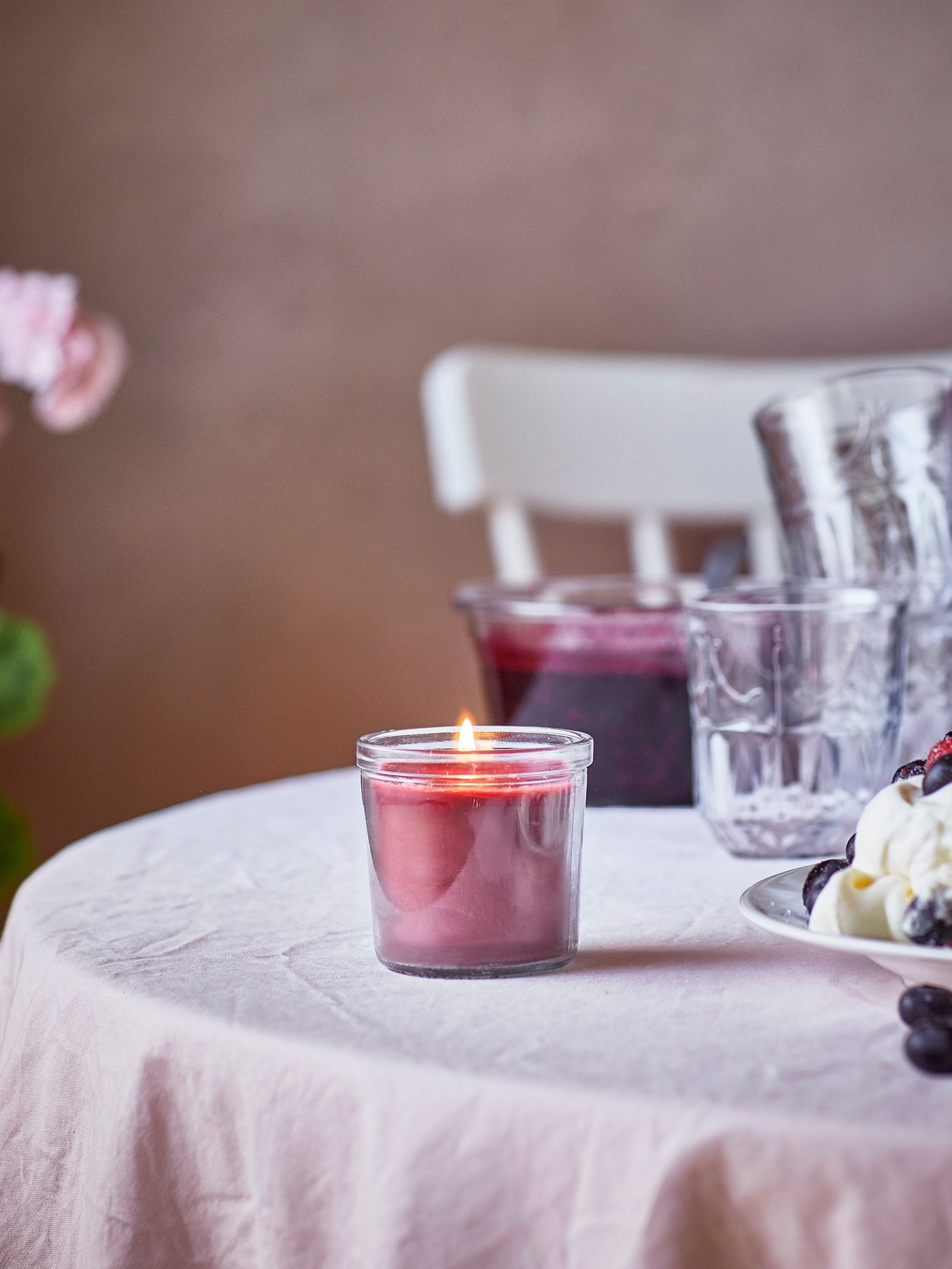 Eine Beeren/rote STÖRTSKÖN-Duftkerze im Glas