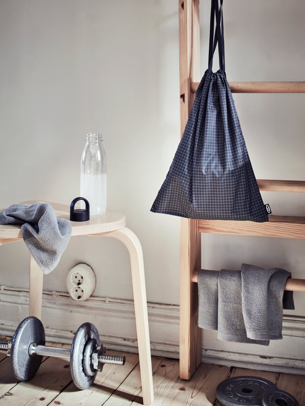 Kawasan pada sepanjang bilik dengan berat sama rata, botol air IKEA 365+, kain lap KORNAN dan beg gim RENSARE.