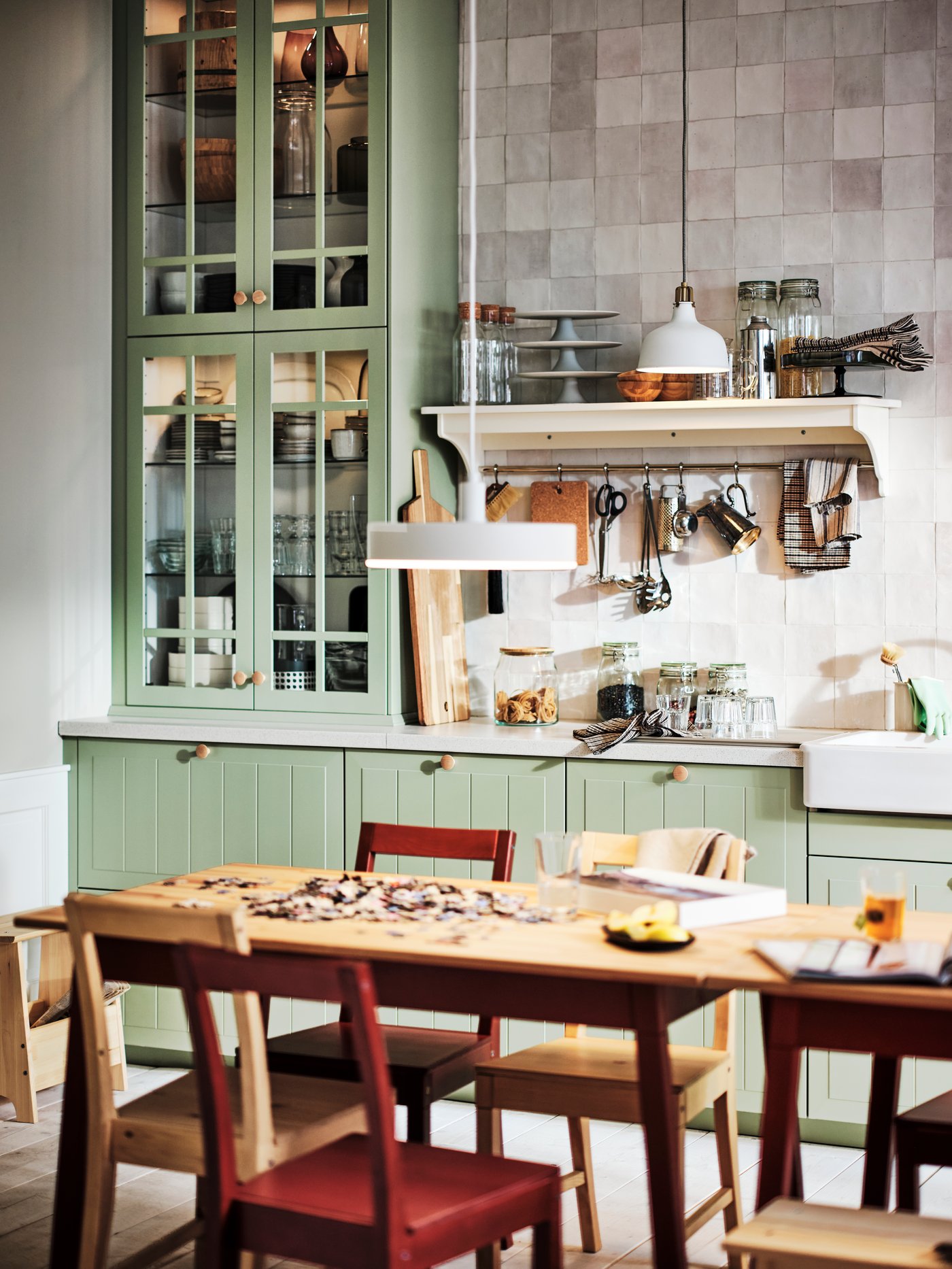 A sage green kitchen cabinet in a small kitchen/dining room