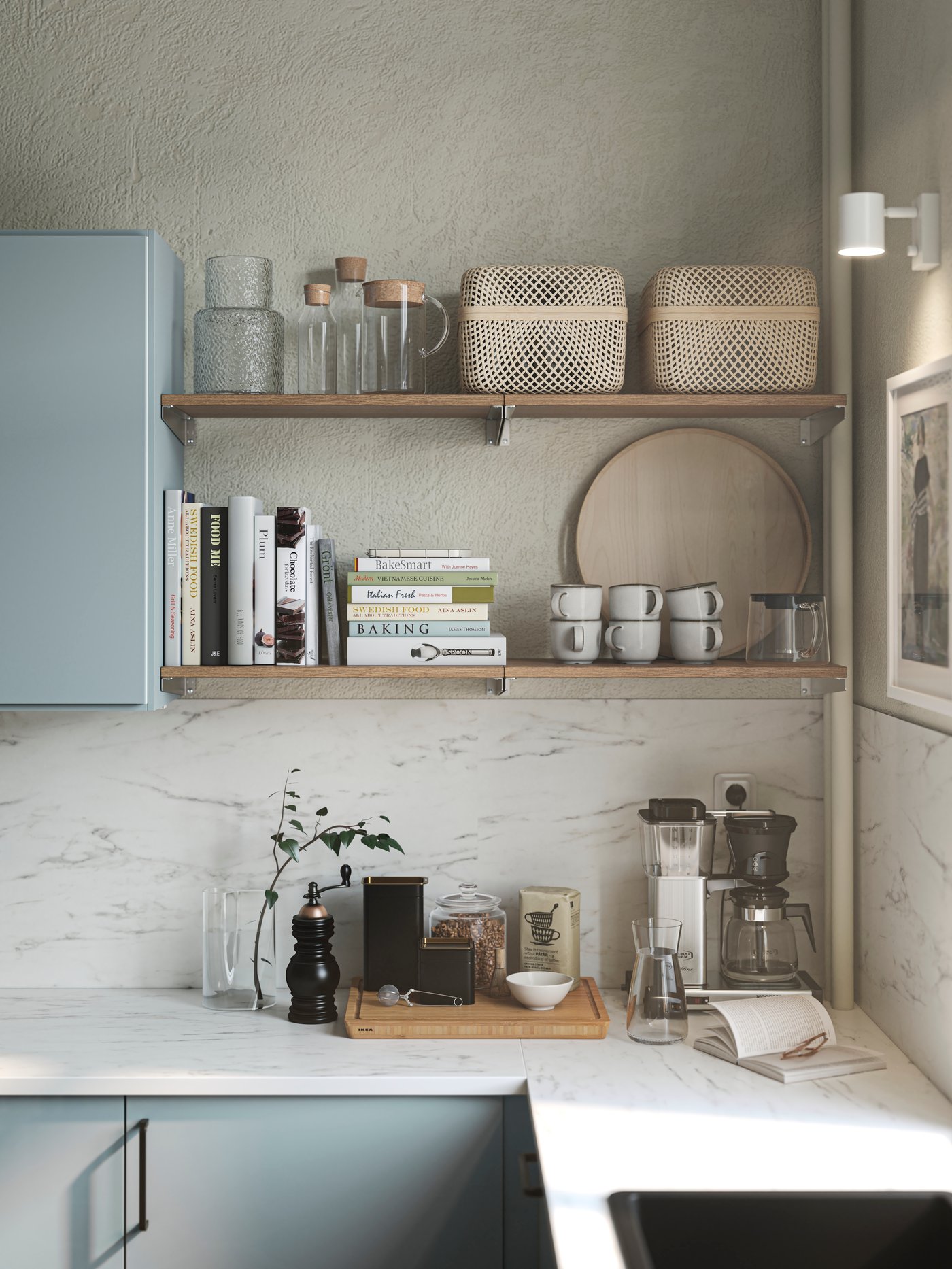 Corner of a IKEA light blue-grey modern kitchen with two open shelves displaying cook books, mugs and storage baskets