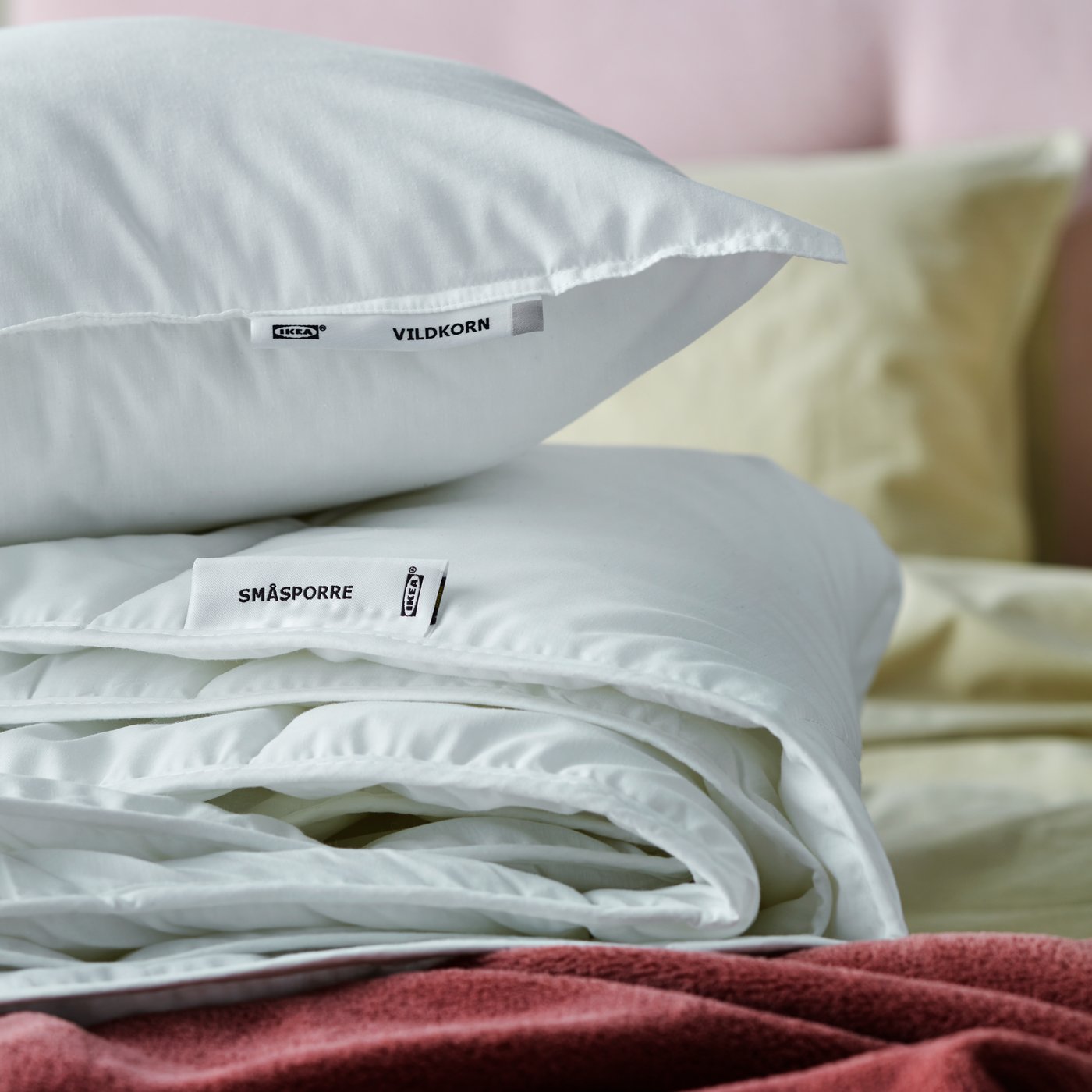 Un oreiller posé sur une couette pliée.