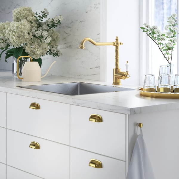 White kitchen cabinet with gold faucet