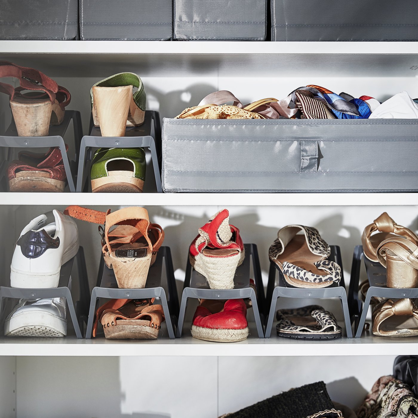 Sept rangements à chaussures MURVEL gris répartis sur deux tablettes, avec une boîte grise contenant des écharpes sur la tablette supérieure.