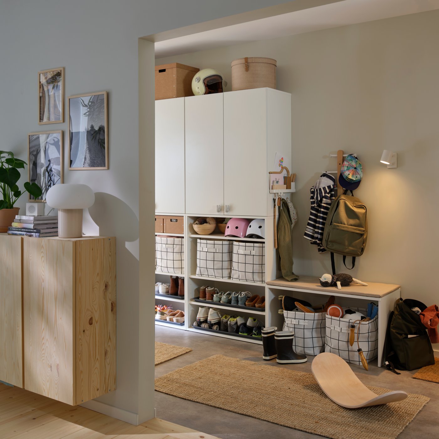 A hallway with LASTARE wardrobe combinations showing closed cabinets above and baskets stored on open shelves.