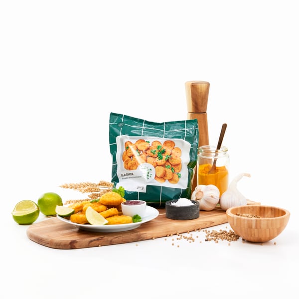 A package of SLAGVERK plant-based pieces next to a plate of the pieces being served with dips and lime slices.