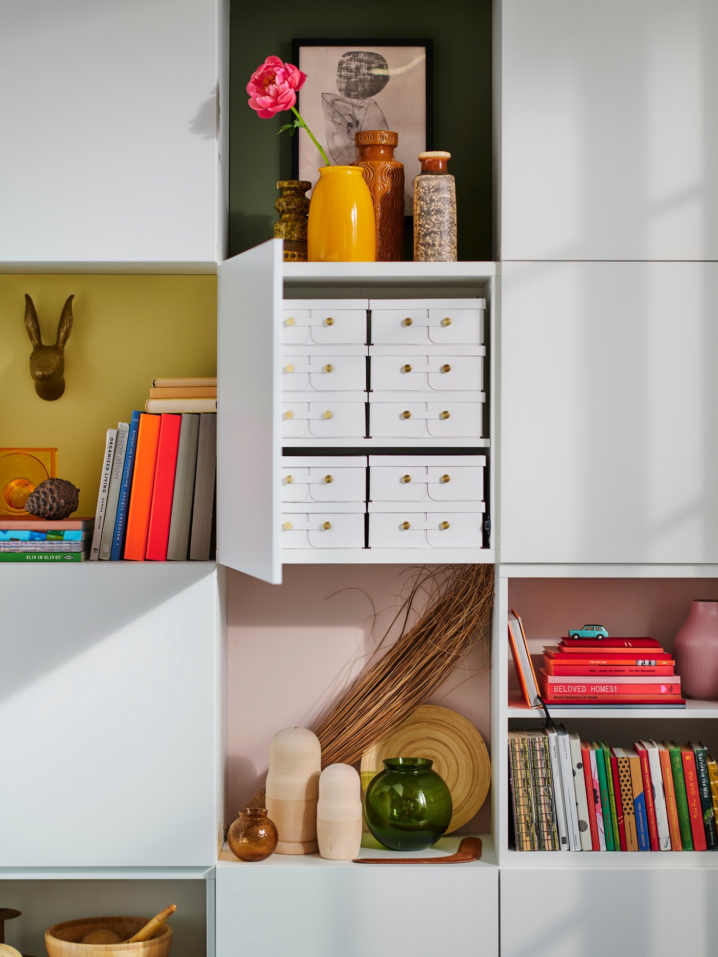 Derrière une table à manger se trouve une bibliothèque pleine d'accessoires d'intérieur et d'espace de rangement.