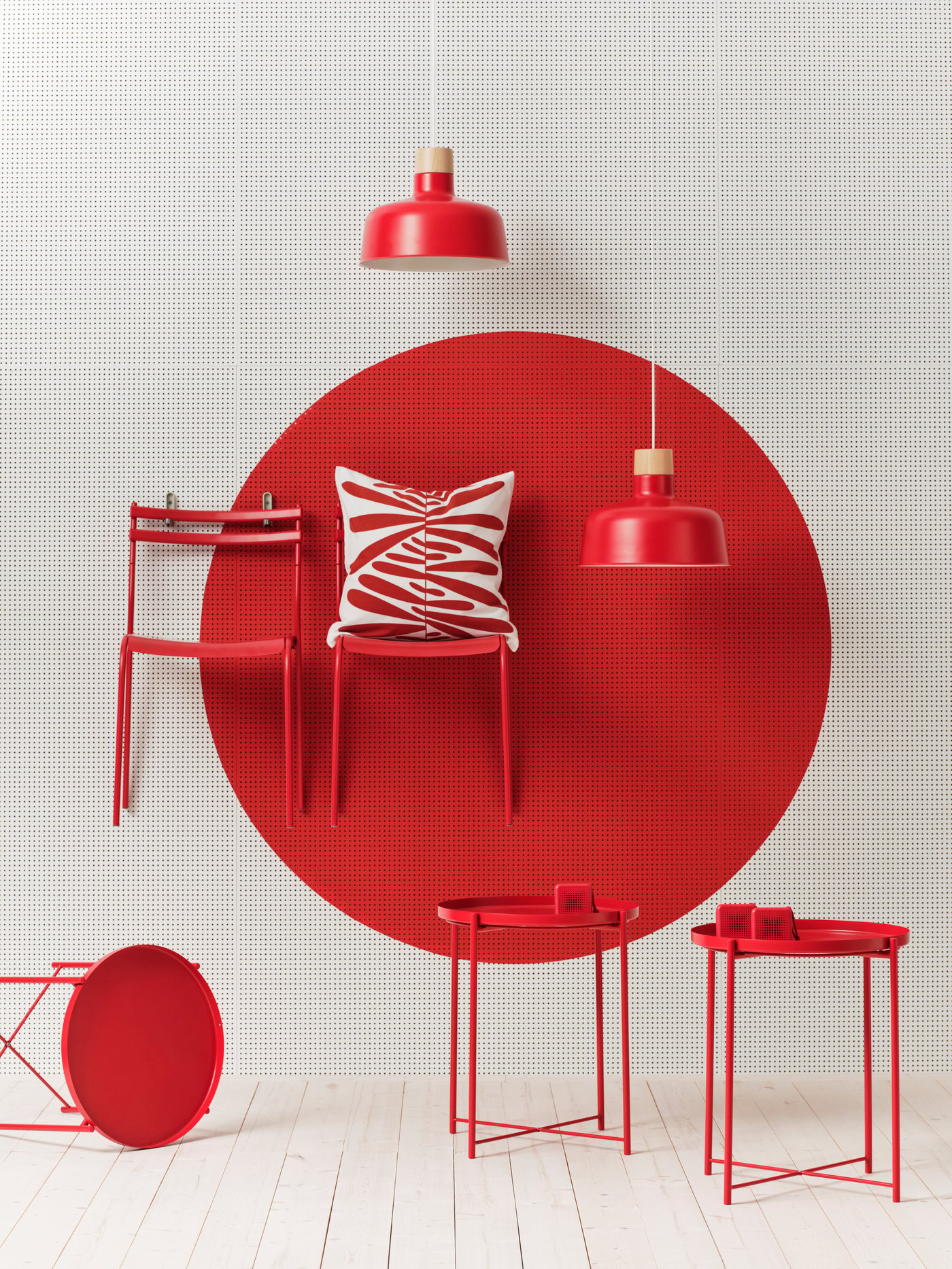 Komplet izdelkov podjetja IKEA v rdeči barvi pred fotografskim studiem z belim ozadjem in belimi tlemi.
