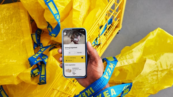ruka držící mbil s IKEA aplikaci a nákupní tašku frakta v ikea