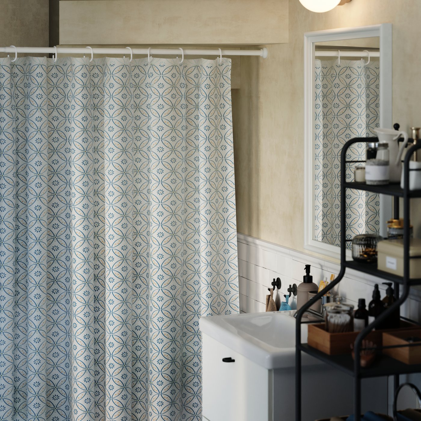 A white BOTAREN shower curtain rod is below a staircase in a half bath, with a shower curtain on it to hide shelving units.