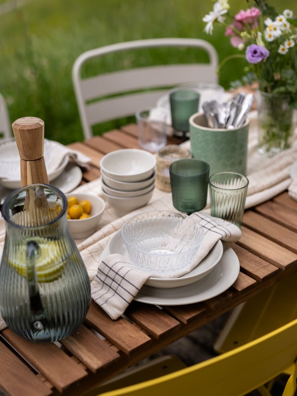 A nice midsummer table setting with linen napkins and a colourful decanter.
