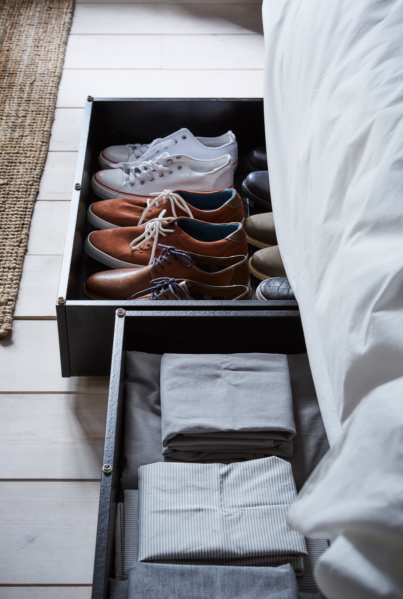 Una caja de almacenamiento para cama VARDÖ negra en el dormitorio.
