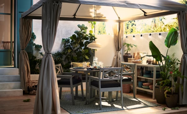 A gray BONDHOLMEN chair with armrests, for outdoor use