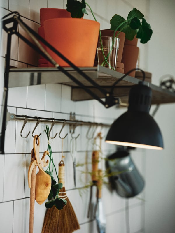 Plant pots on a stainless steel KUNGSFORS shelf above a nickel-plated HULTARP rail with nickel-plated HULTARP hooks.