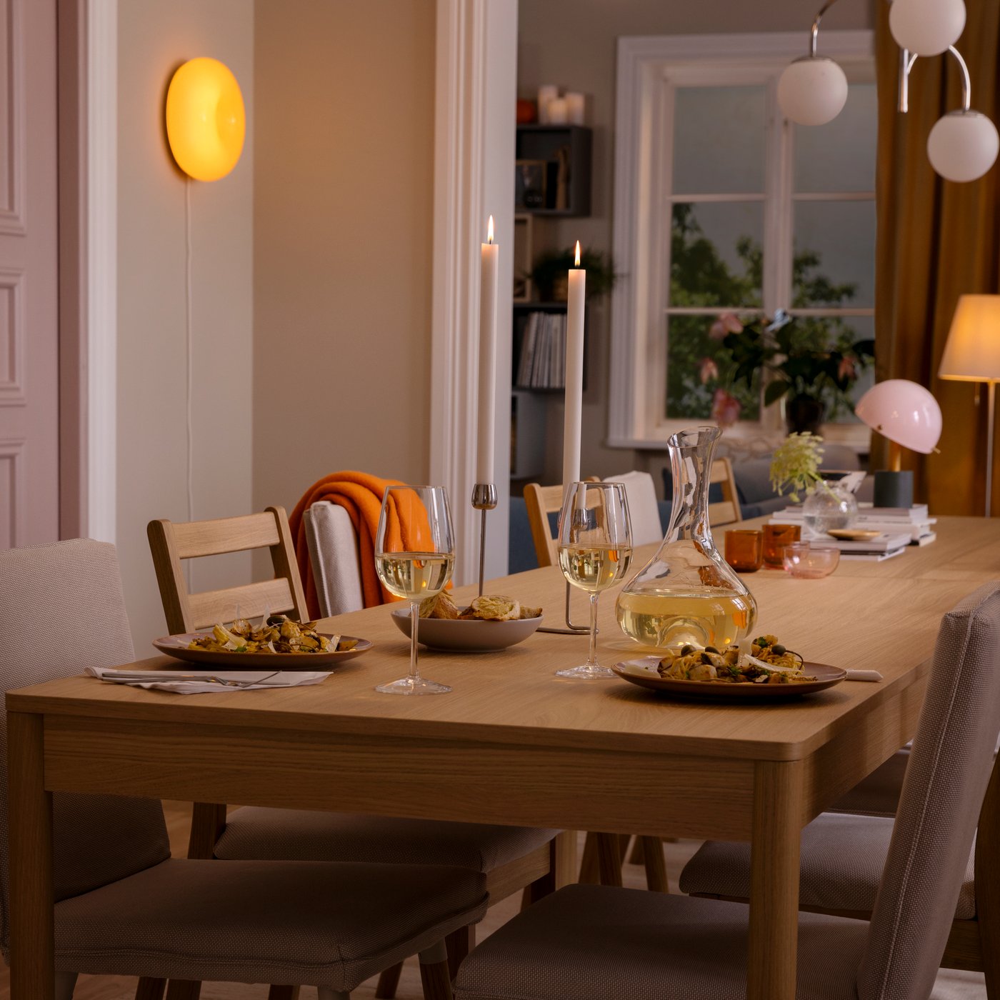 Table TONSTAD en plaqué chêne prête pour un repas de fête : verres STORSINT, carafe STORSINT et vaisselle FÄRKLAR.