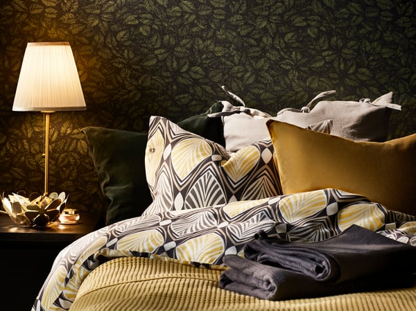 A grey/yellow HÄSTFIBLA quilt cover and pillowcase in the bedroom