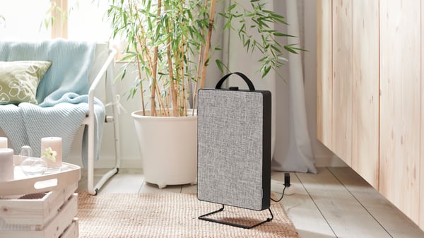 A black FÖRNUFTIG air purifier in the living room