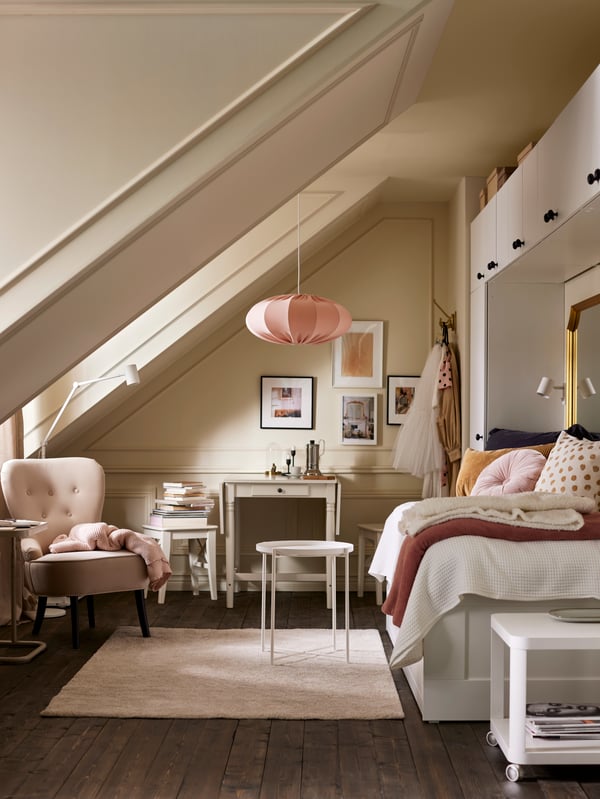 A bright room with a daybed, white wardrobes, a white GLADOM tray table on a beige rug, a beige armchair and pink pendant.