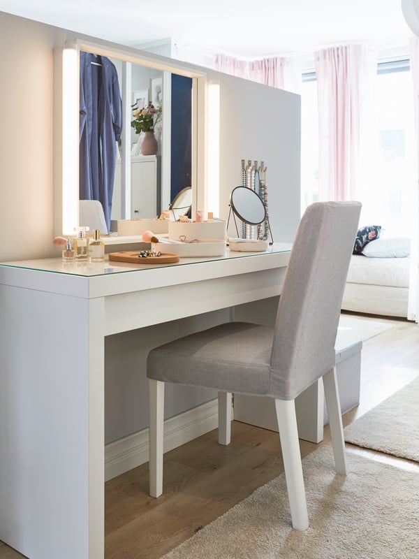 A white RAKSTA LED wall/mirror lamp in the bedroom