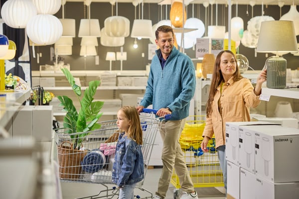 A family walking with a trolley in an IKEA store.
