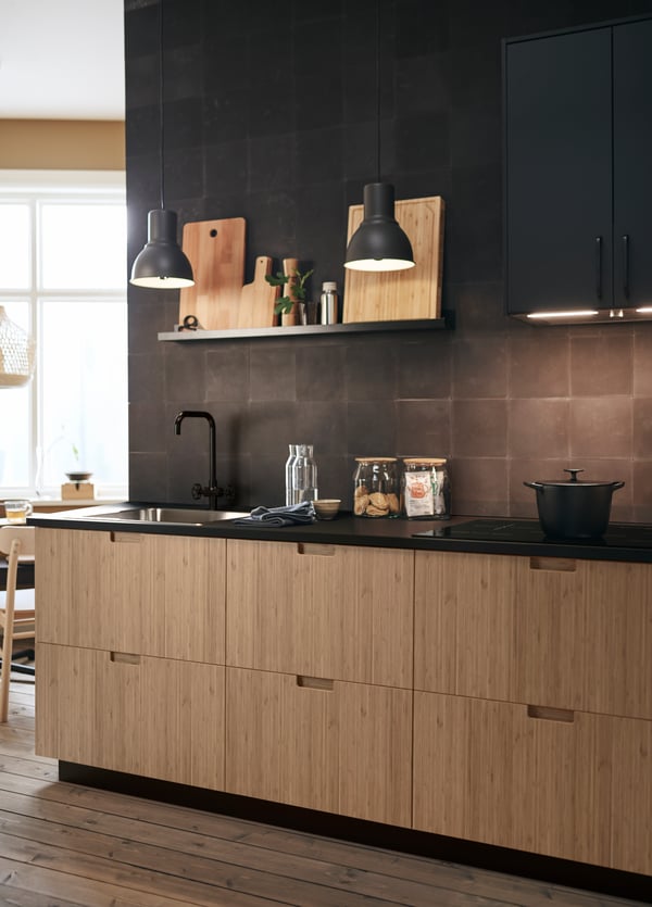 In this modern kitchen, FRÖJERED kitchen fronts in bamboo are paired with black tiled backsplash and accessories.