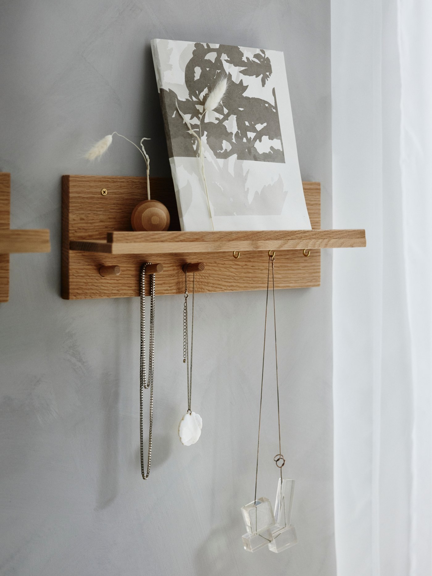 HÄSTVISKARE on a grey wall showing decorative items and hooks with accessories.