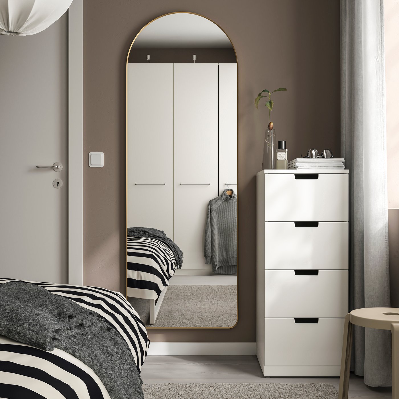 Un miroir LINDBYN doré dans la chambre à coucher.