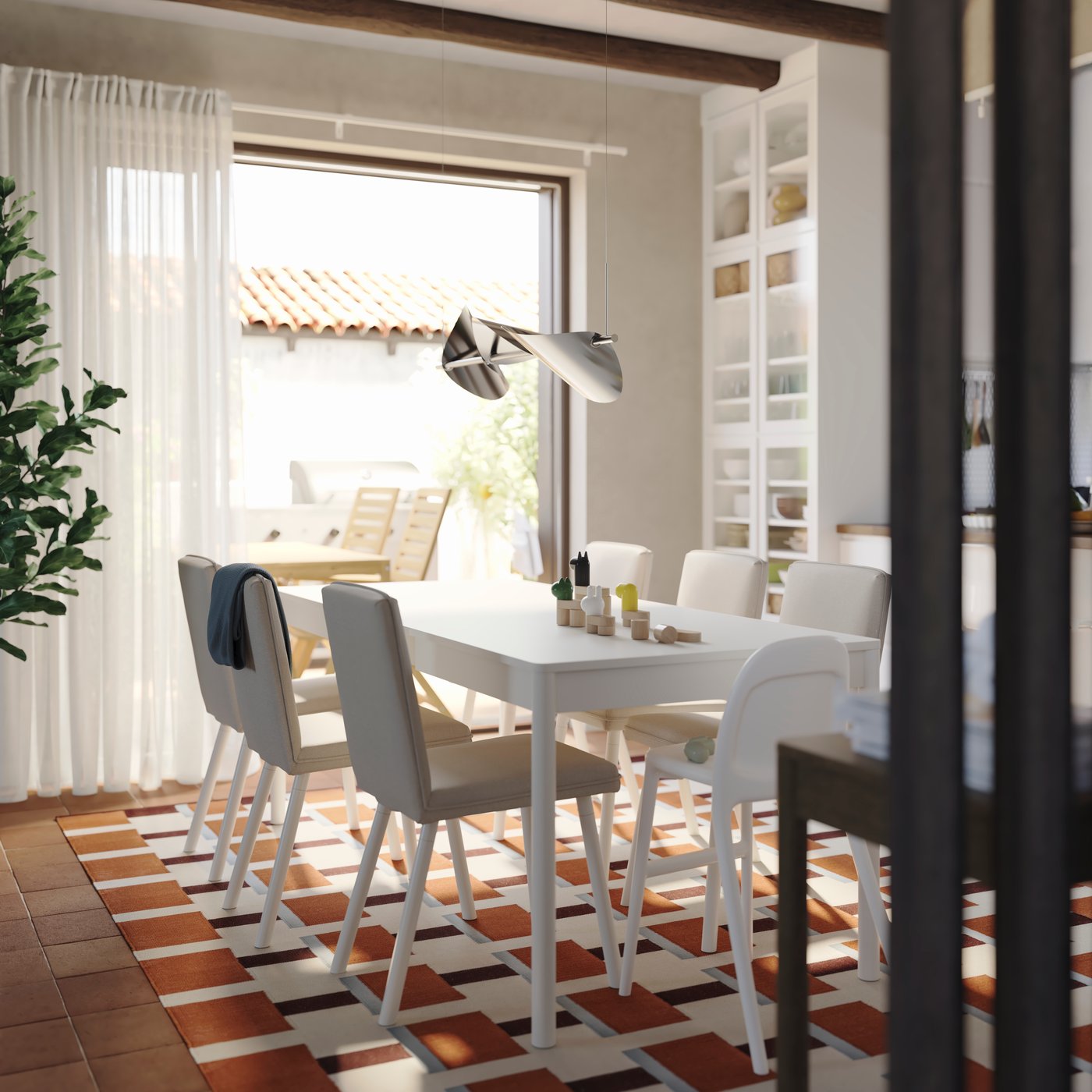 A bright dining room has a TONSTAD extendable table in off-white with six matching chairs and a cabinet with glass doors.